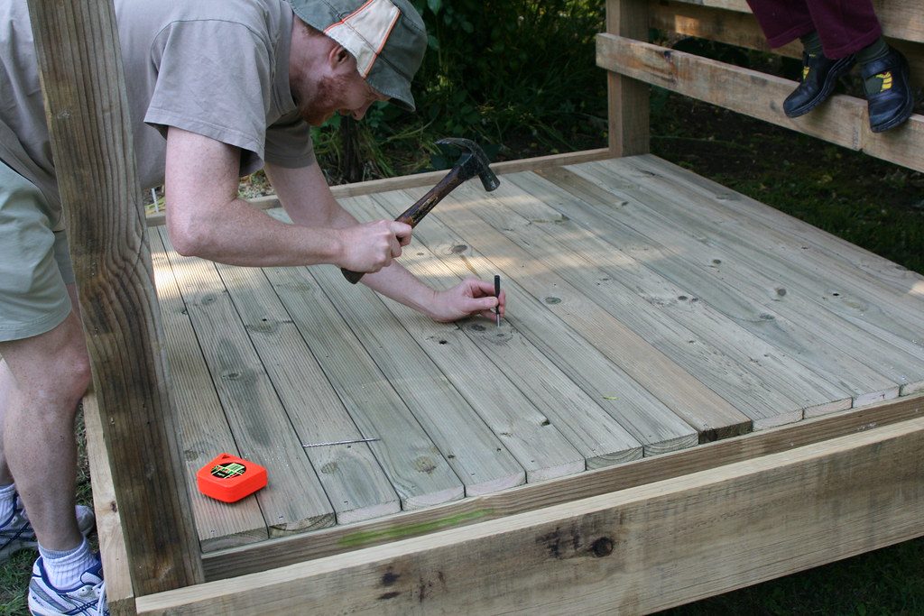 Builder hammering deck boards into place